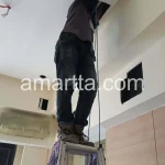 teknisi memasang kabel lan pada plafon ruangan hotel