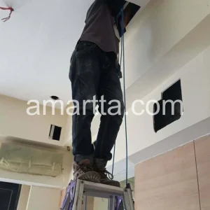 teknisi memasang kabel lan pada plafon ruangan hotel