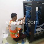 teknisi merapikan kabel jaringan di rack server