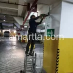 Teknisi melakukan Penarikan Kabel CCTV di basement tempat parkir