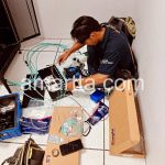 teknisi melakukan splicing fiber optik dengan alat